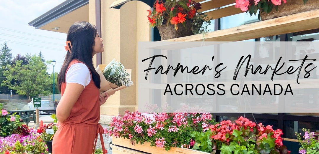 A woman looks at a display of flowers at a country market, while wearing a bamboo jumpsuit and bamboo t-shirt.