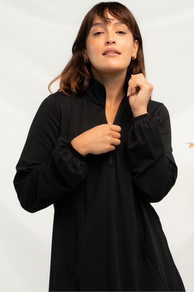 Close up of the zipper collar on the balloon sleeve dress in black.