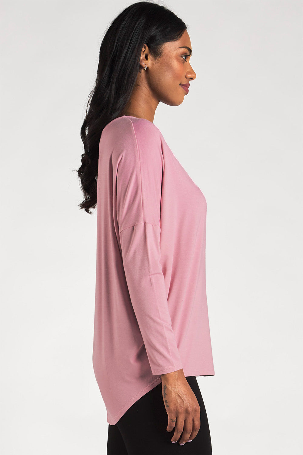 Side view of a woman styling a Pink long sleeve top by Terrera.