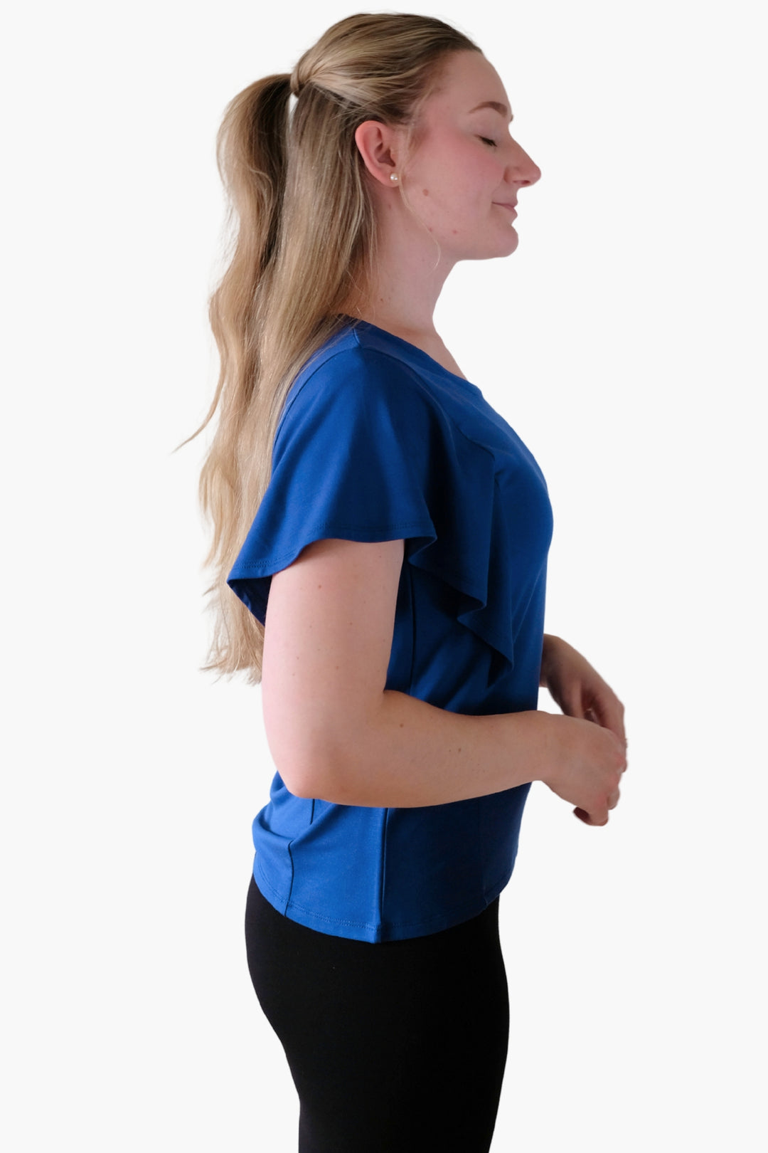 A woman wearing a blue top with ruffled sleeves 