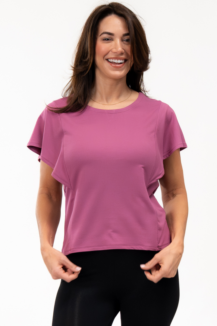 A woman wearing a pink shirt and black bamboo leggings 