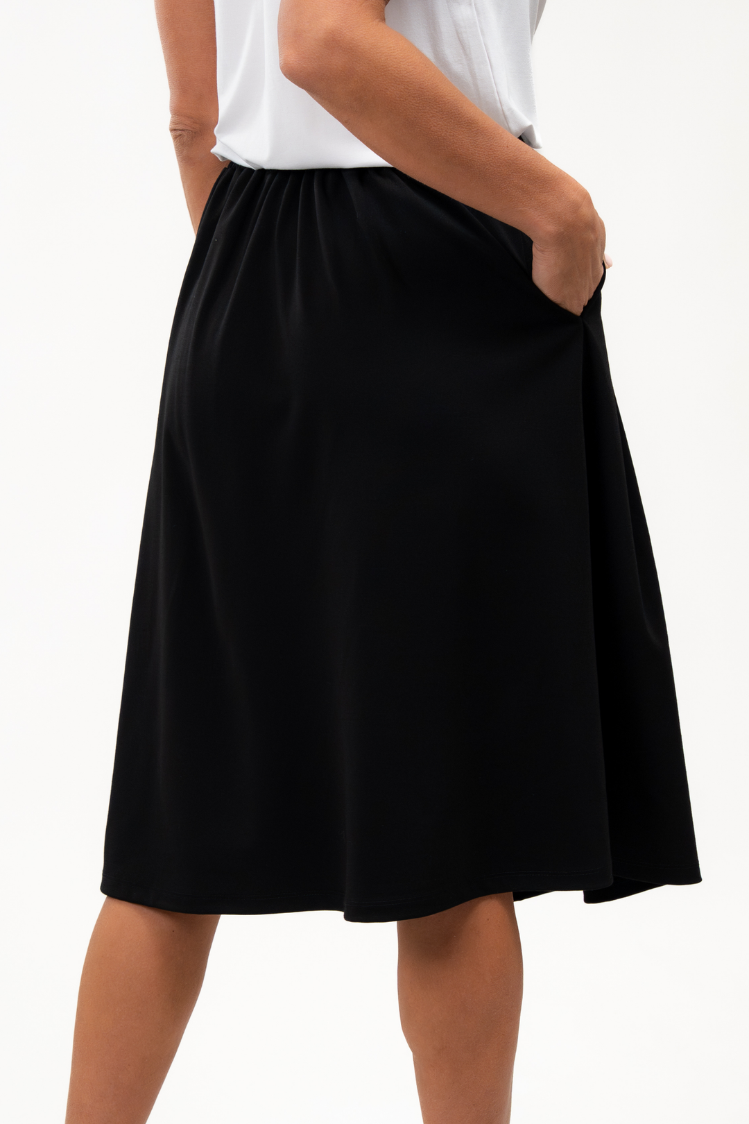 Woman wearing a white t-shirt and black skirt on a white background