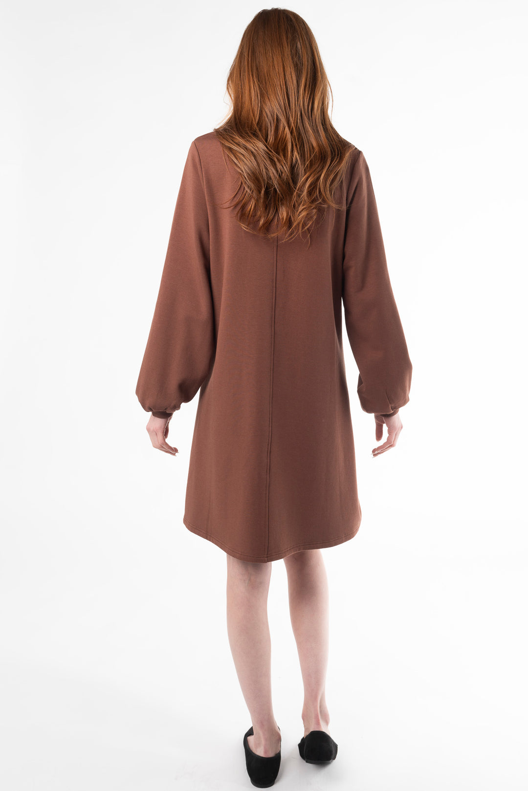 Back view of a woman modeling a puff sleeve dress in Black by Terrera.