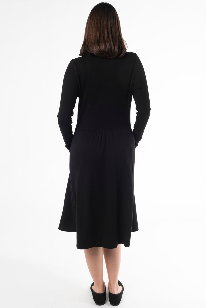 Back view of a woman modeling a black midi dress in the colour Black by Terrera.