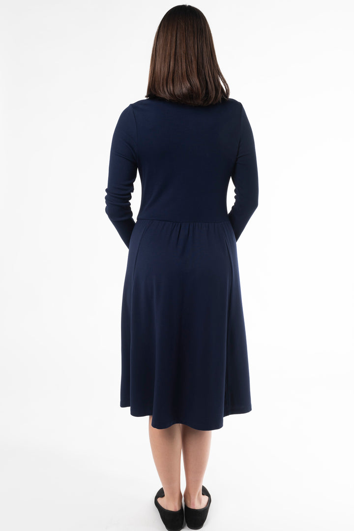 Back view of a woman modeling a navy midi dress in the colour Ink by Terrera.