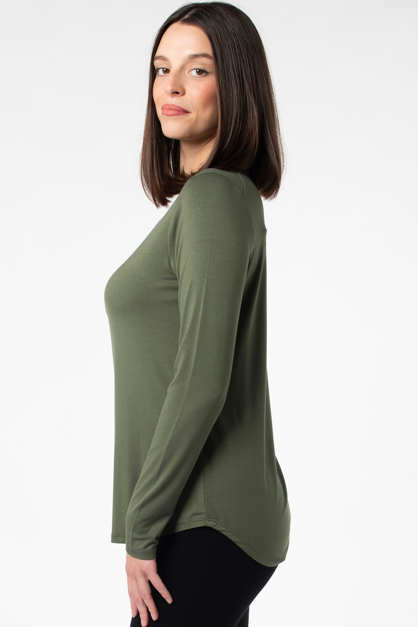 Side view of a closet staple long sleeve top with a crew neckline, made with sustainable bamboo fabric. Featuring a high low bottom hem for more coverage in the back.