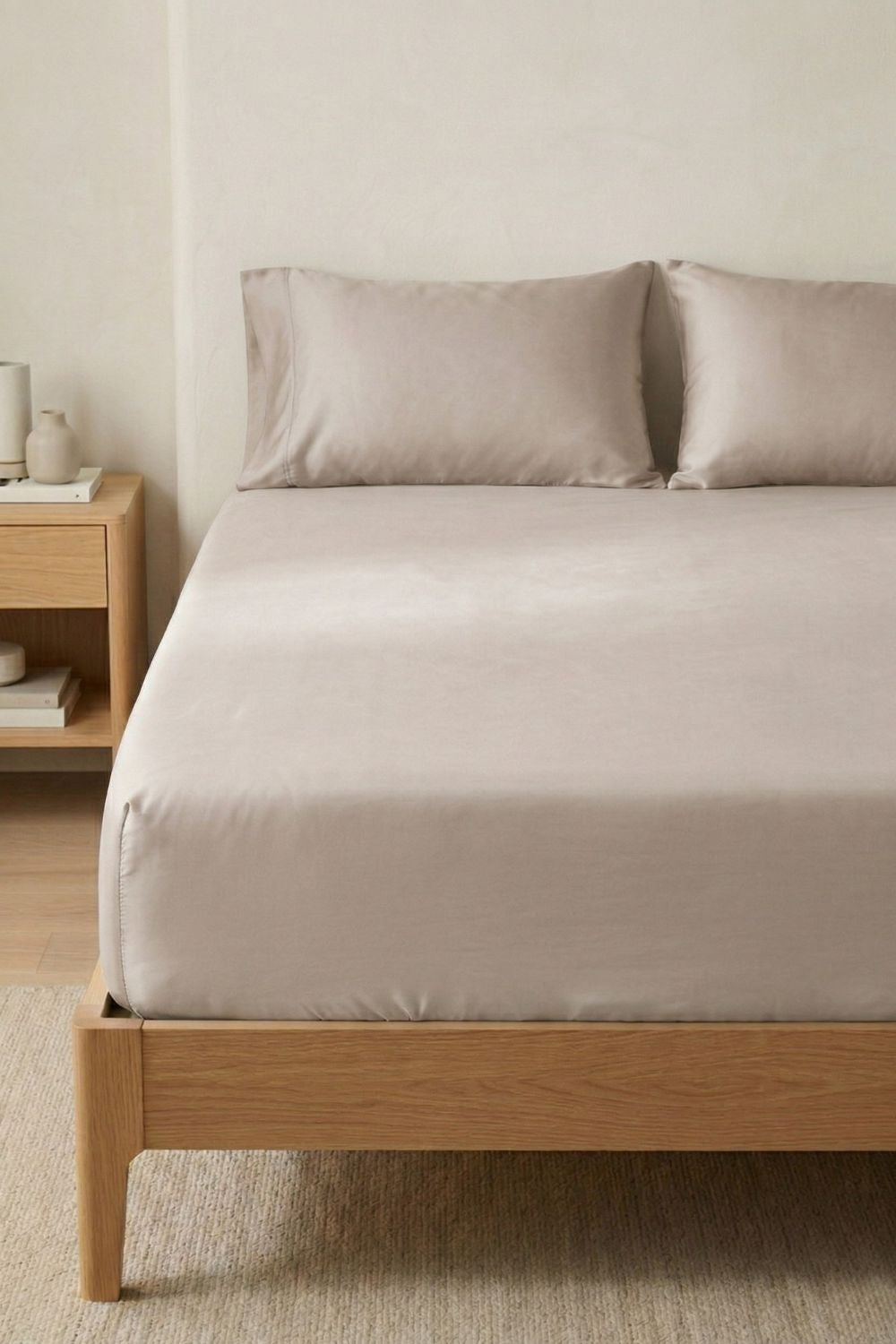 Sustainable warm taupe fitted bed sheet in a neutral bedroom.