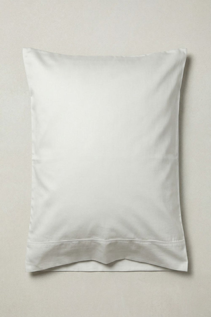 Warm white standard size pillow on a grey background