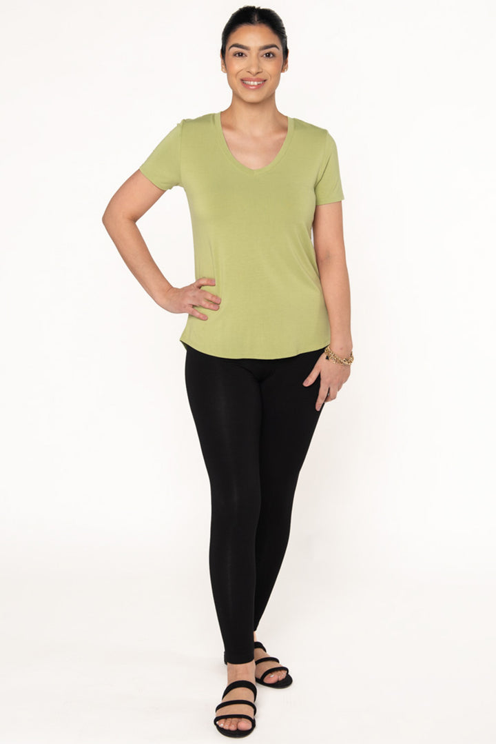 Model wearing a green v-neck t-shirt paired with bamboo leggings and black sandals. 
