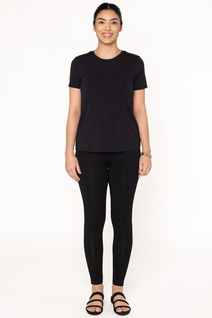 A model wearing a black bamboo short sleeve t-shirt with a crew neckline paired with black bamboo leggings and black sandals.