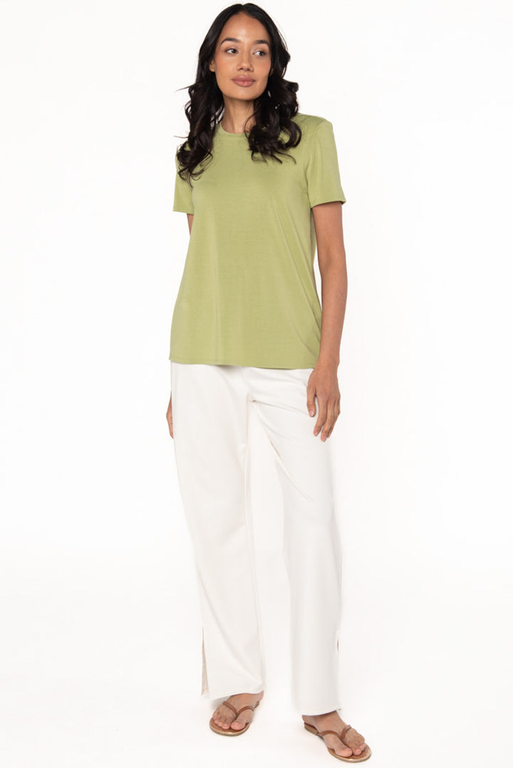 Model wearing a light green bamboo t-shirt paired with a cream coloured bamboo straight leg pant.