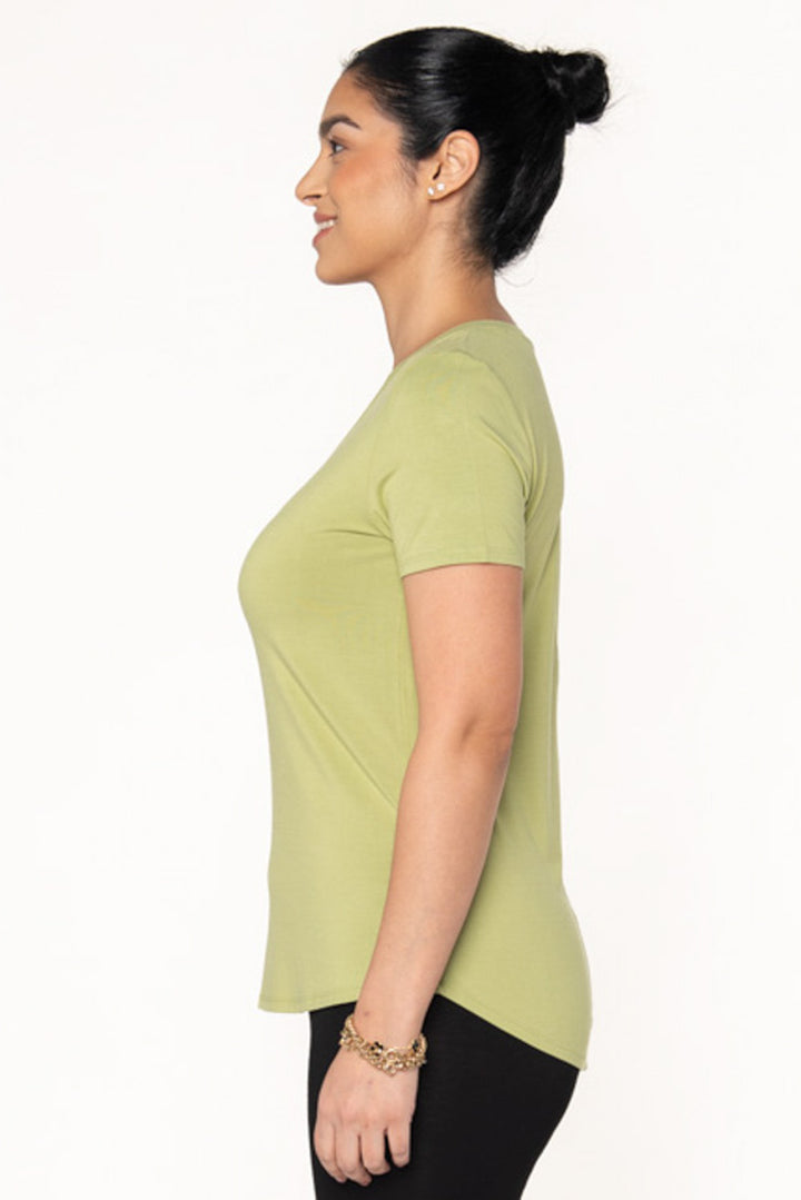 Bamboo t-shirt with a v-neckline in a light green colour by Terrera. The model is showing the side view of the v-neck t-shirt made from bamboo. It features a high-low hemline.