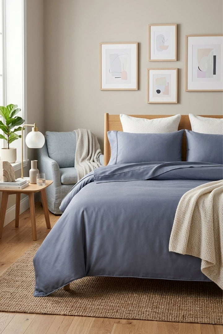 Neatly made bed with blue bamboo bedding in a bedroom setting.