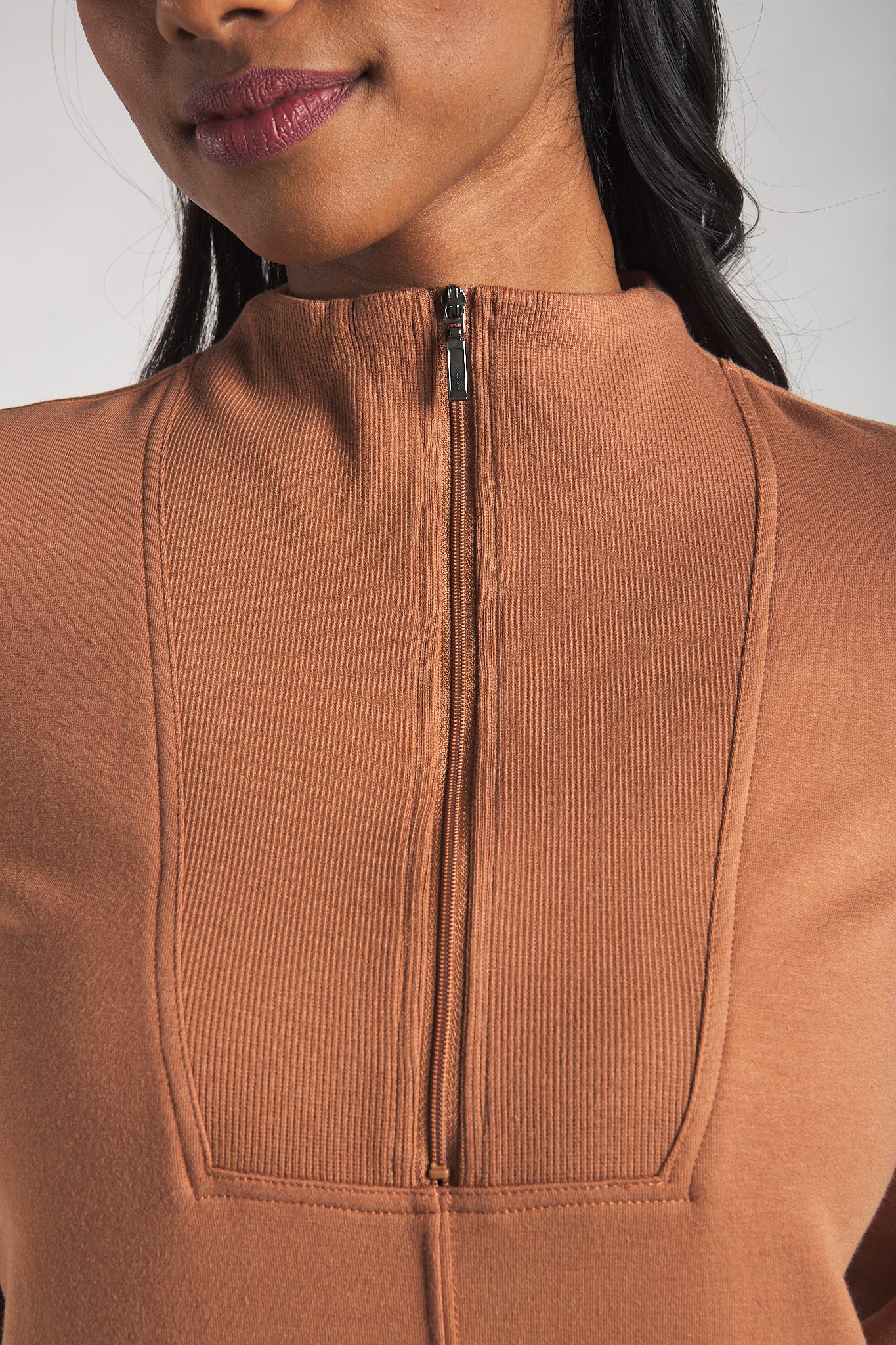 Closeup image of the half-zip detail on the Terrera fleece dress in the colour Warm Brown.