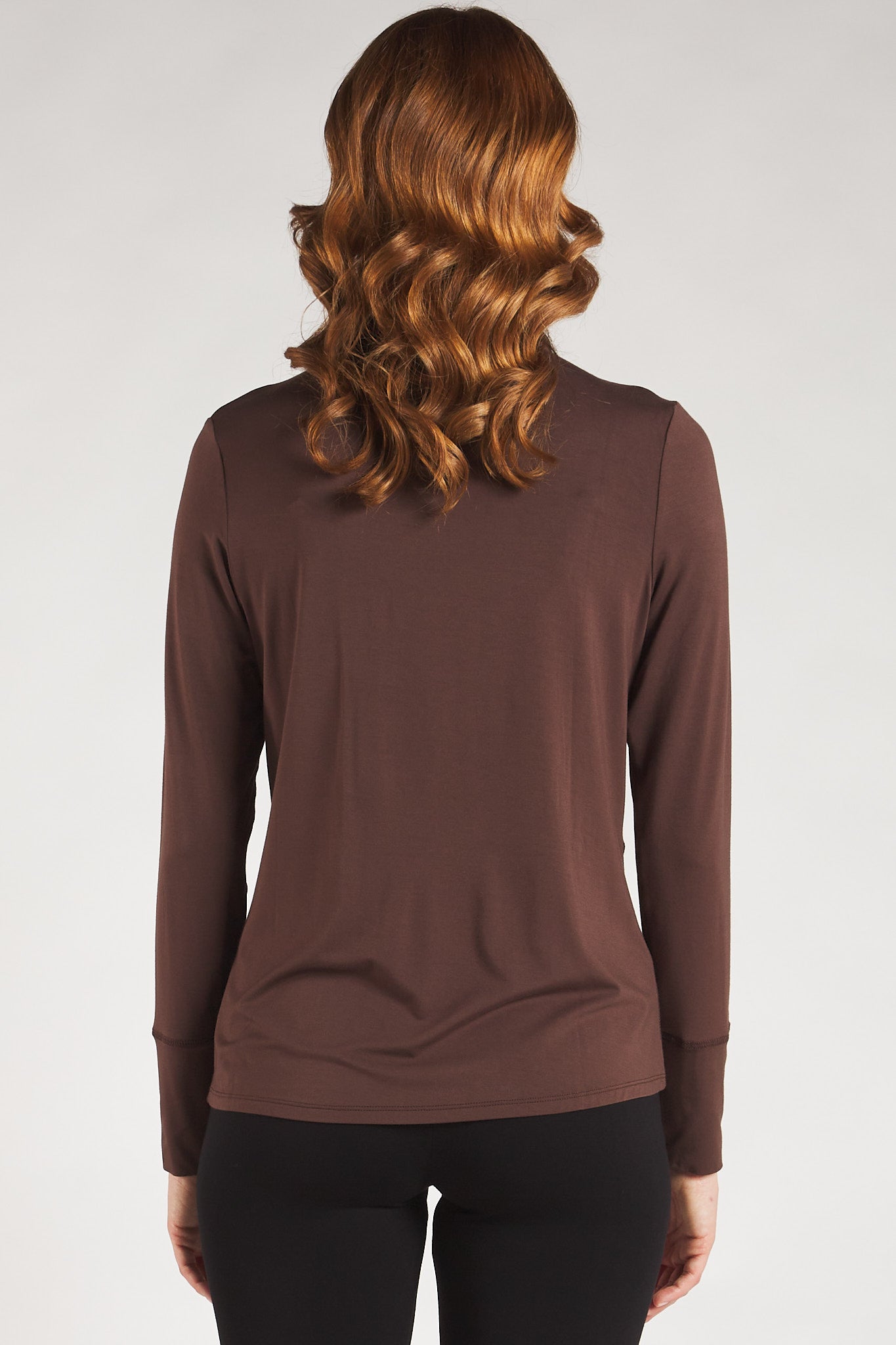 Back view of a woman styling a brown long sleeve turtleneck top from Terrera.