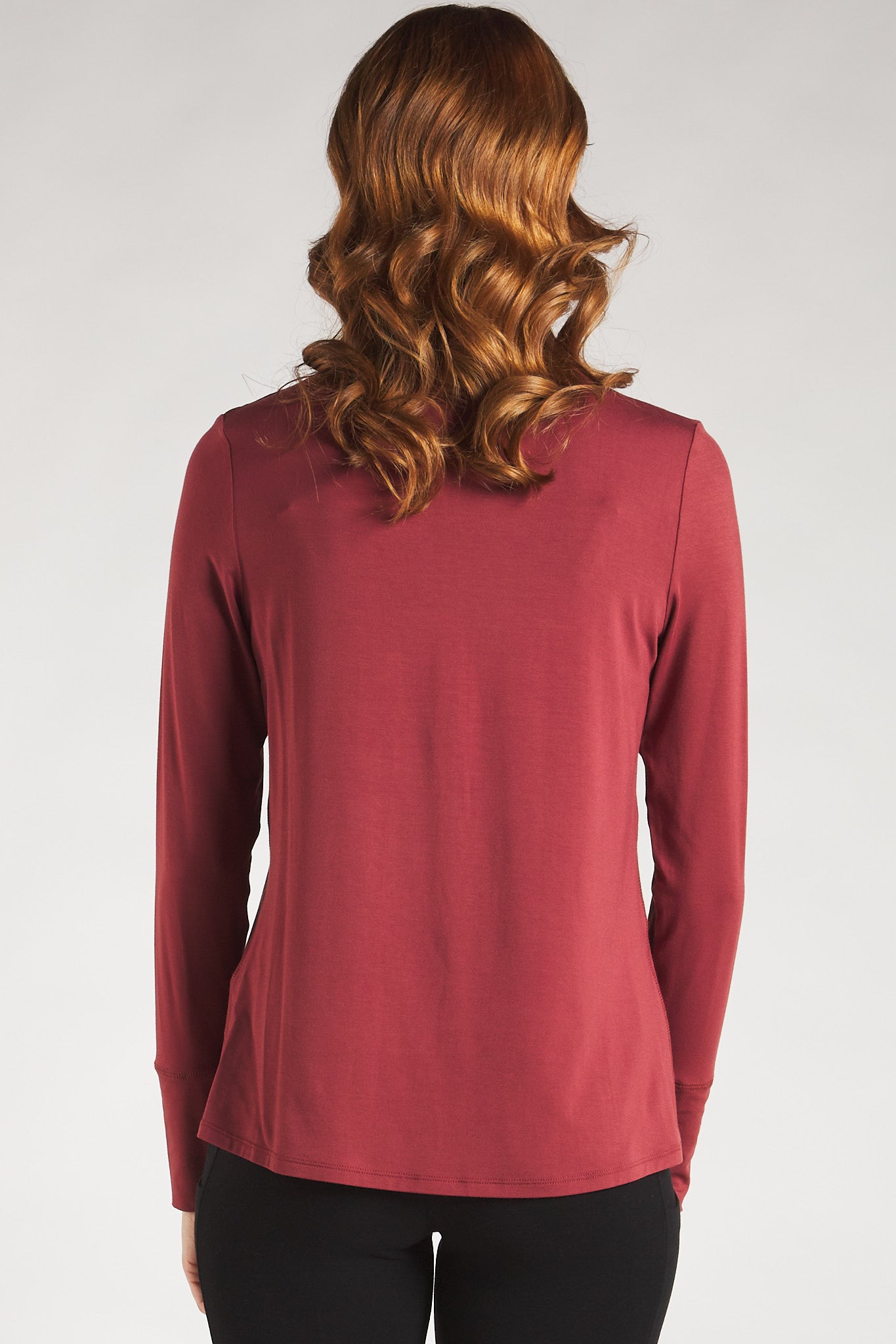 Back view of a woman styling a Rosewood long sleeve turtleneck top from Terrera.