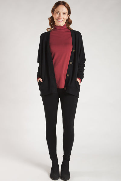 Woman styling a Rosewood long sleeve turtleneck top with a black sweater from Terrera.