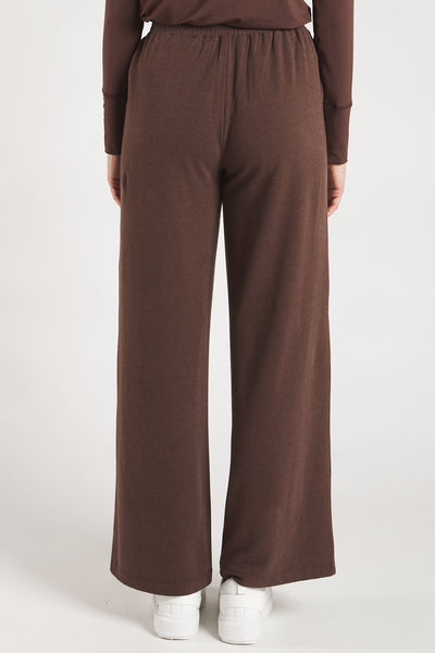 Back view of a woman styling Coffee Bean sustainable wide leg pants from Terrera.