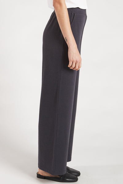 Side view of a woman styling Slate Grey wide leg pants made from sustainable bamboo. 