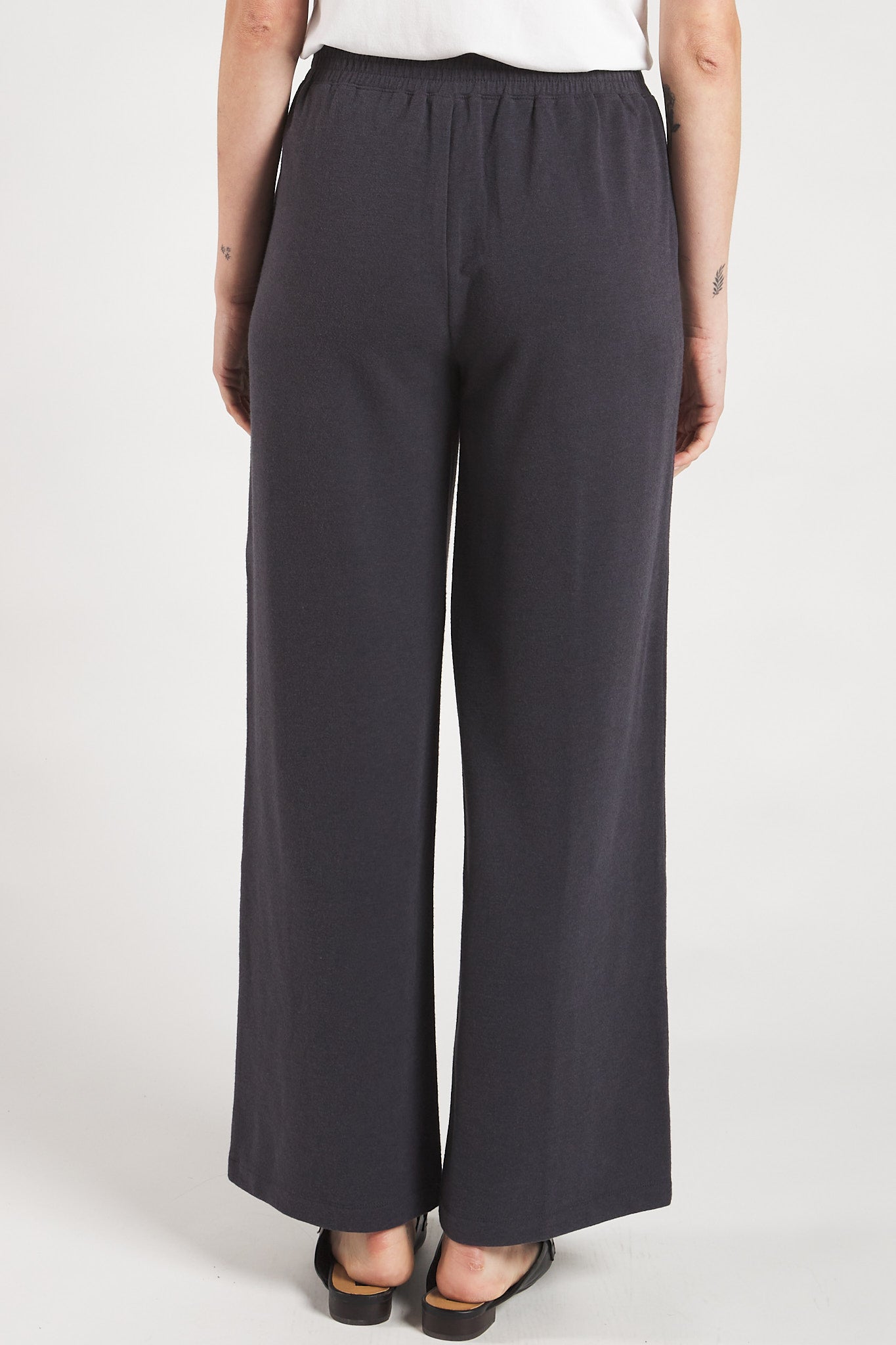 Back view of a woman styling Slate Grey sustainable wide leg pants from Terrera. 