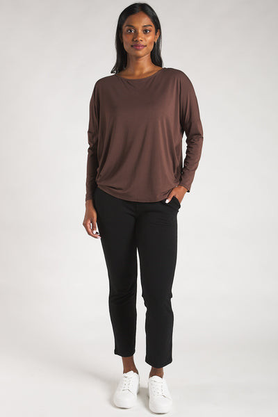 Woman styling a sustainable bamboo long sleeve top in dark brown by Terrera.