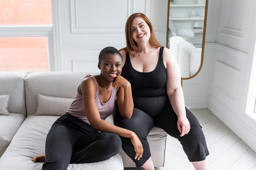 two women sitting on the couch wearing bamboo tanks in black and mauve colours by Terrera