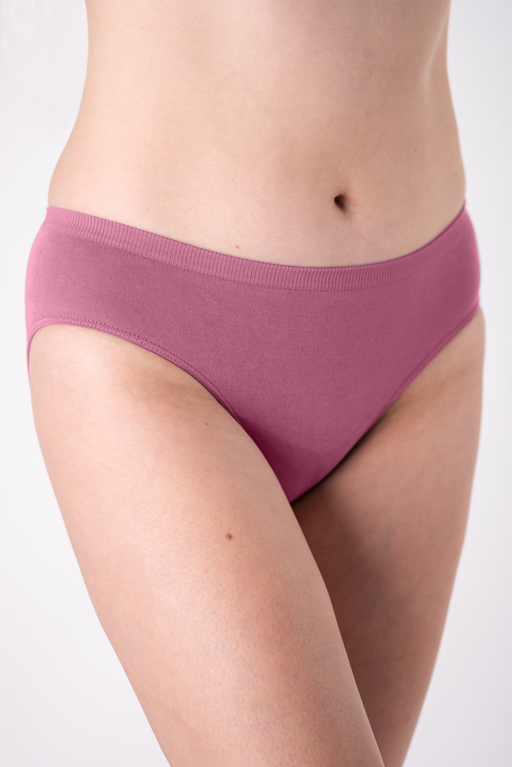 A woman wearing a pair of pink mid-rise underwear on a white background