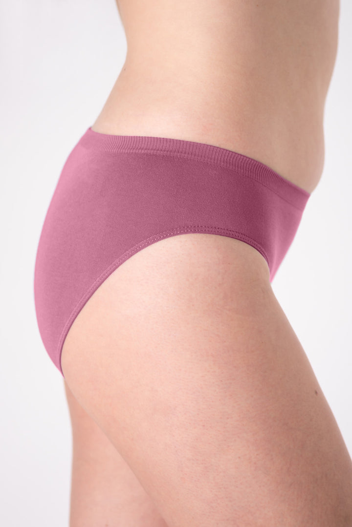 A woman wearing a pair of pink mid-rise underwear on a white background